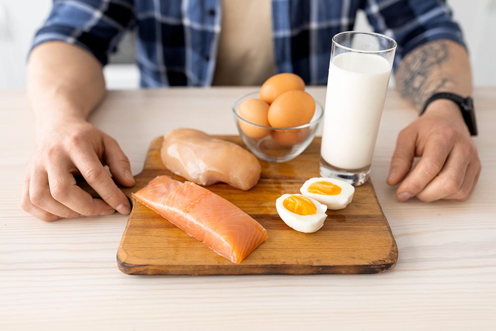 man sitting in front of a plate of healthy protein foods